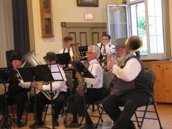 (from left to right) Members of the Orono Cornet Band playing rotary valve trombone, bass saxhorn, ophicleide and helicon.