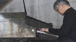 Sakamoto playing the tsunami piano.
