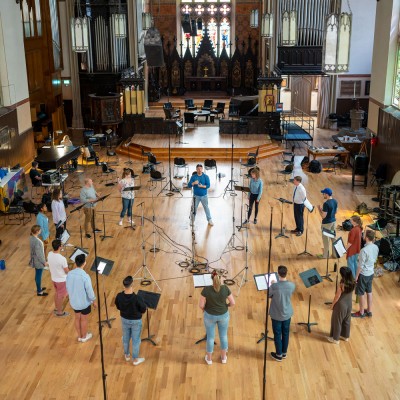 That Choir, led by Craig Pike (centre) at Church of the Holy Trinity (Toronto) in a May 2022 recording session for their 2022 self-titled album. That Choir is now a professional 16-member choir that offers all singers wages and health benefits. This recent shift to professional status fosters “a work culture in which artists feel healthy, creative, and valued.” 
