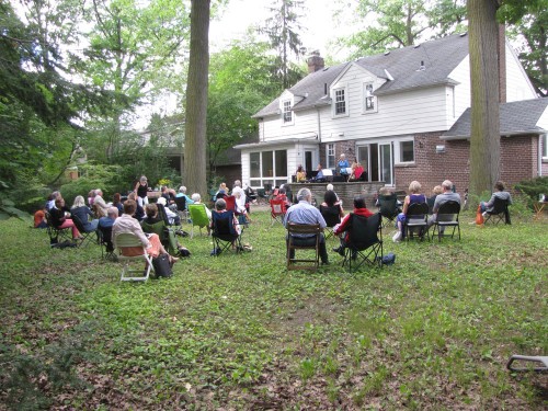 A carefully spaced backyard audience enjoys The Encore Take Five Quintet. Photo by Jack MacQuarrie
