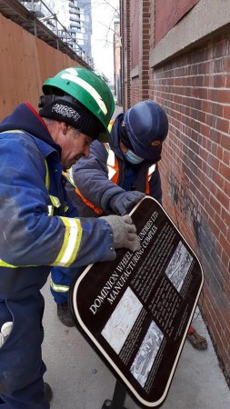 Workers removing plaque. Photo credit TWITTER @MCALLISTER_MARK