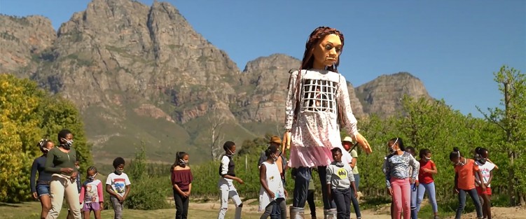 Puppeteers and school children rehearse for Little Amal's very first walk at the Boschendal winery in Franschhoek, South Africa, September 2020. Photo still from video by Alide Dasnois.