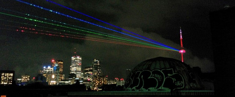 From the roof of the Green P parking lot in Kensington Market: Global Rainbow - created by Yvette Mattern. Nuit Blanche, Toronto (2014). Photo by Luca Perlman.